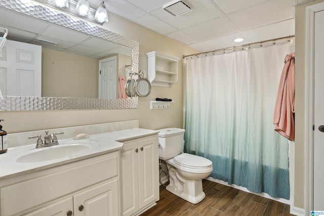 bathroom featuring vanity, visible vents, wood tiled floor, a paneled ceiling, and toilet