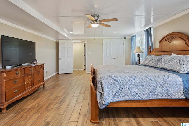 bedroom featuring a closet, ceiling fan, baseboards, and wood finished floors