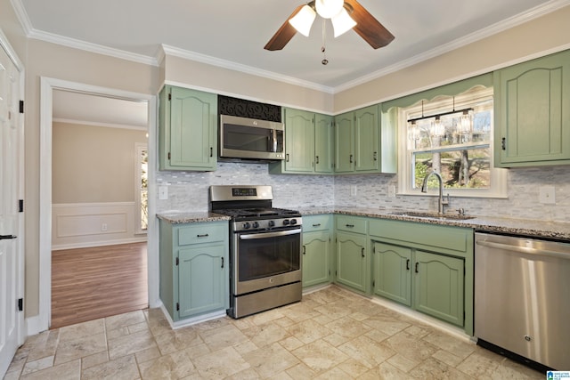 kitchen featuring stone tile flooring, stainless steel appliances, green cabinets, and a sink