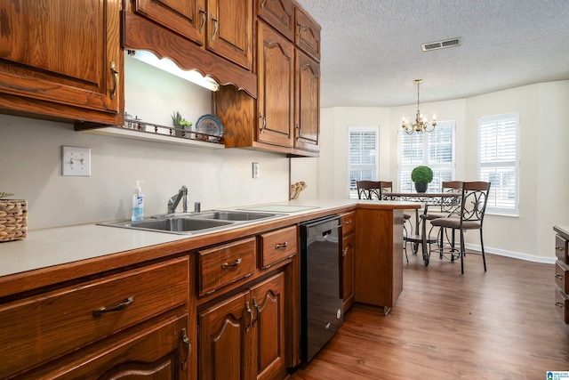 kitchen with visible vents, a sink, dark wood finished floors, light countertops, and dishwashing machine