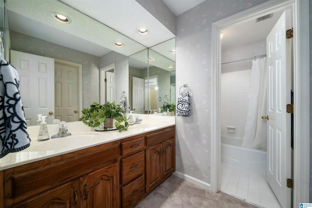 full bath with wallpapered walls, double vanity, baseboards, and a sink