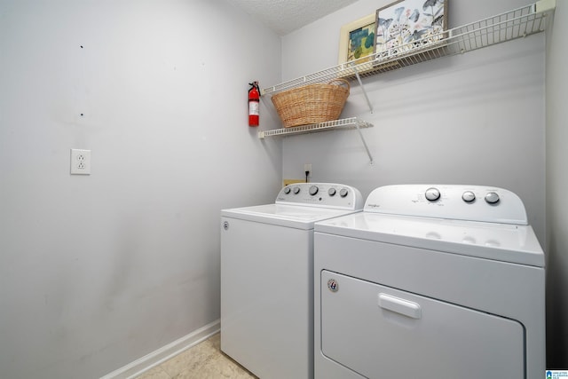 washroom with baseboards, separate washer and dryer, laundry area, and a textured ceiling