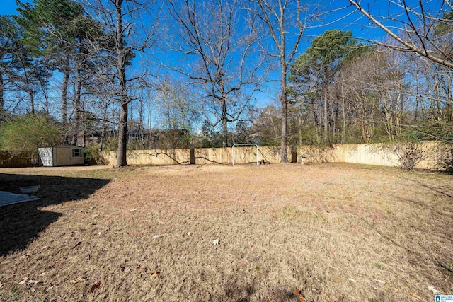 view of yard featuring an outbuilding, a shed, and a fenced backyard