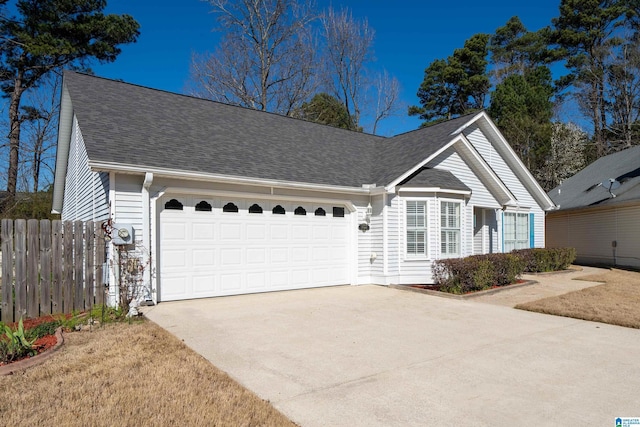 ranch-style home featuring an attached garage, a shingled roof, driveway, and fence