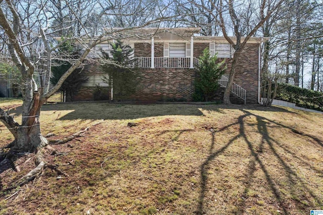 view of side of home featuring brick siding and a lawn