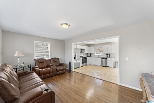 living room with baseboards and light wood finished floors