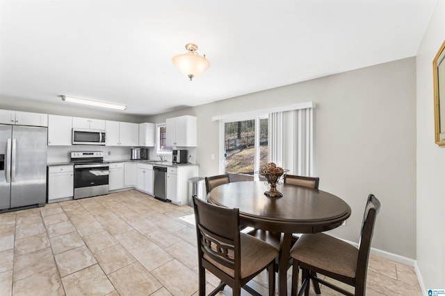 dining room with baseboards and light tile patterned flooring