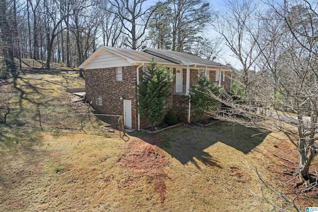 view of property exterior featuring fence and brick siding