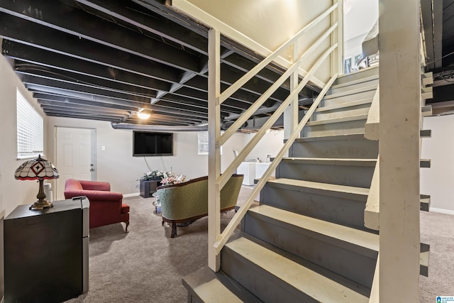 staircase featuring baseboards and carpet floors