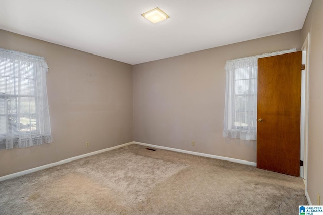 spare room with visible vents, baseboards, and carpet floors