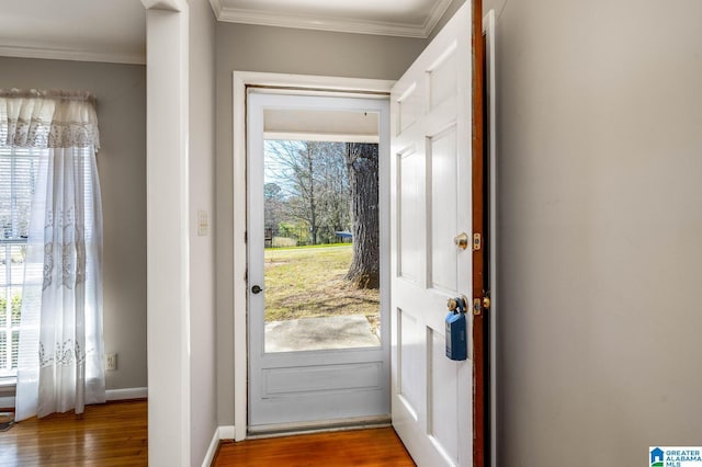 doorway with a wealth of natural light, wood finished floors, and crown molding