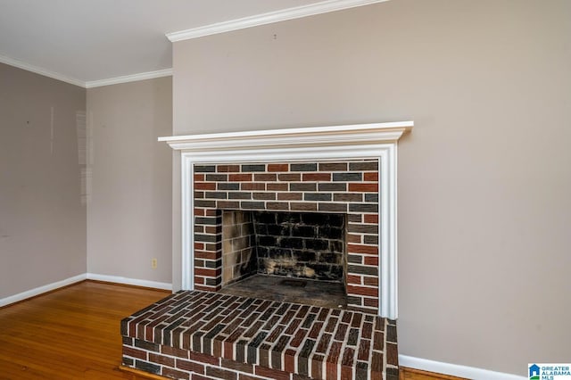 details featuring a brick fireplace, crown molding, baseboards, and wood finished floors