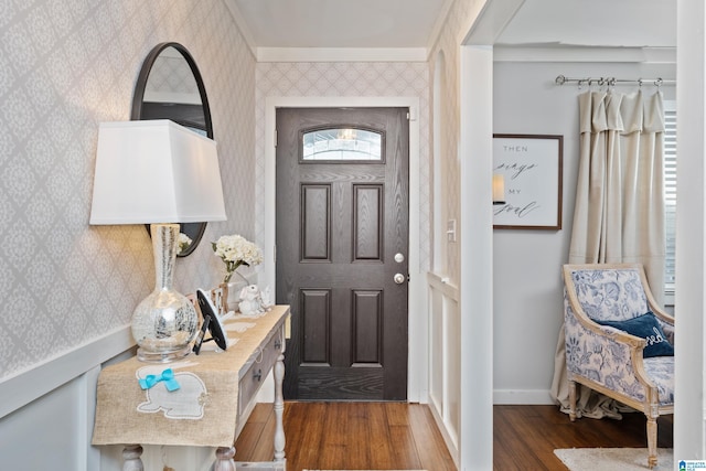 foyer entrance with wallpapered walls, dark wood-type flooring, and baseboards