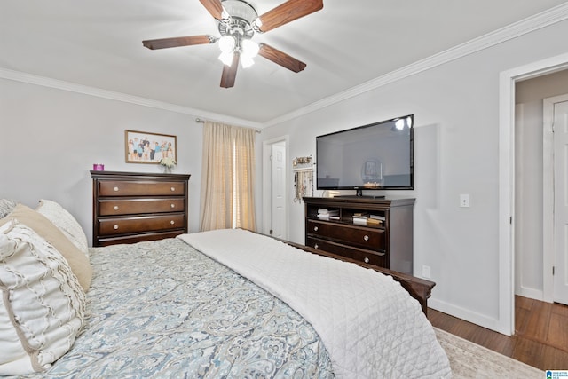 bedroom featuring a ceiling fan, wood finished floors, baseboards, and ornamental molding