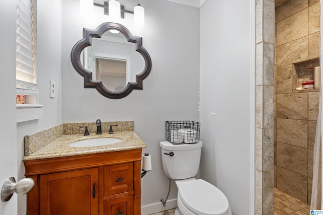 bathroom featuring baseboards, toilet, a stall shower, and vanity