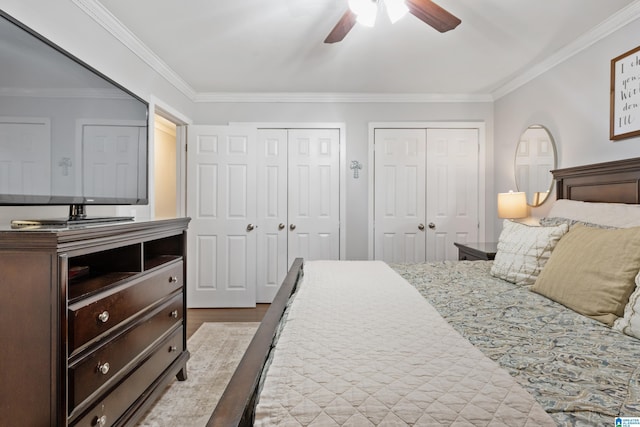 bedroom featuring two closets, ceiling fan, and crown molding