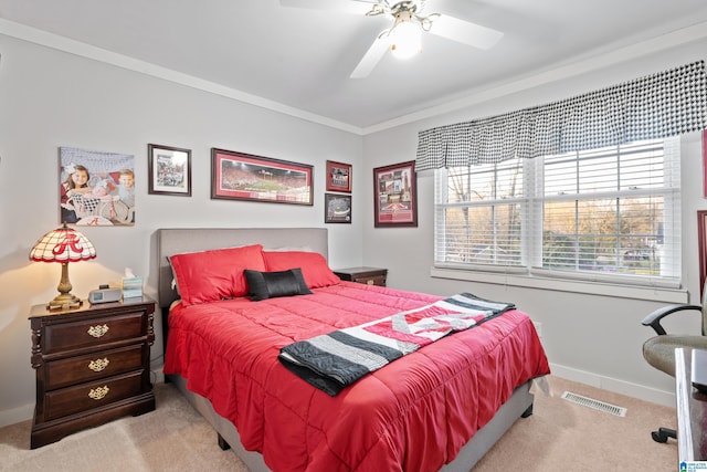 bedroom featuring a ceiling fan, baseboards, carpet, visible vents, and ornamental molding