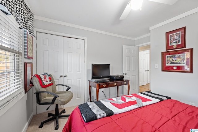 bedroom featuring a closet, carpet floors, crown molding, baseboards, and ceiling fan