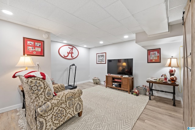 living area featuring baseboards and light wood finished floors