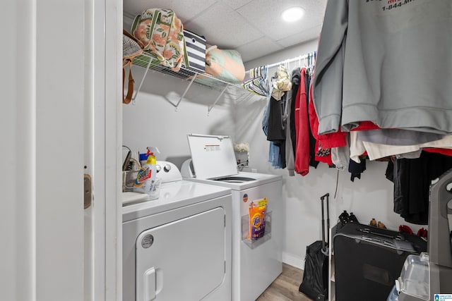 laundry area featuring laundry area, separate washer and dryer, baseboards, and light wood finished floors