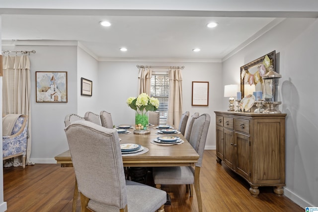 dining room featuring ornamental molding, baseboards, and wood finished floors