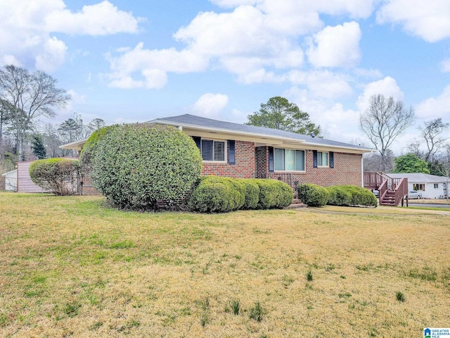 ranch-style home featuring a front lawn and brick siding