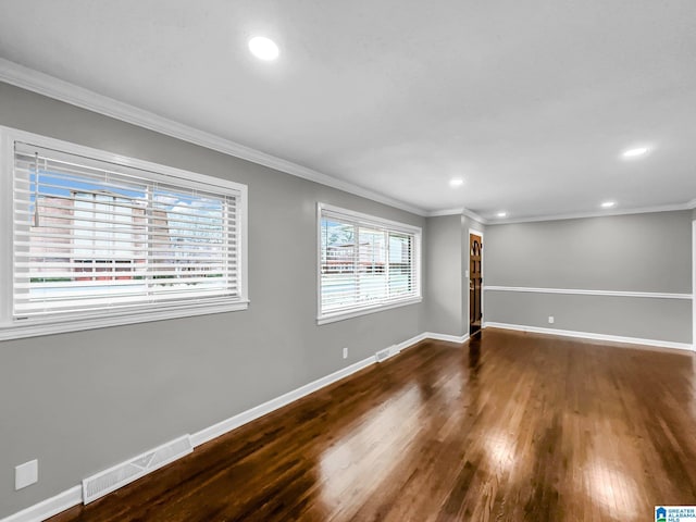 empty room with visible vents, baseboards, and wood finished floors