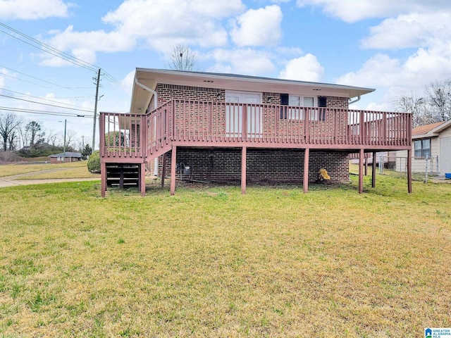 back of house featuring a yard, brick siding, and a wooden deck