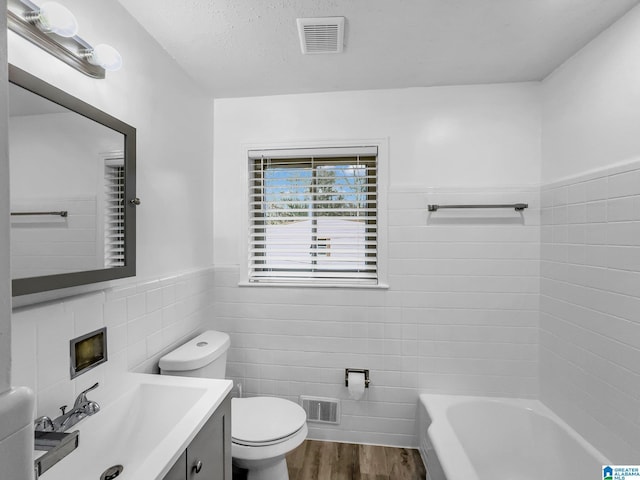 bathroom featuring visible vents, toilet, tile walls, and wood finished floors