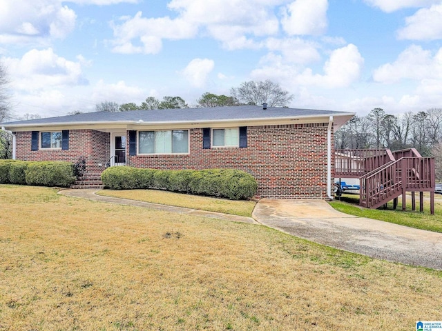 ranch-style home with brick siding, concrete driveway, and a front lawn