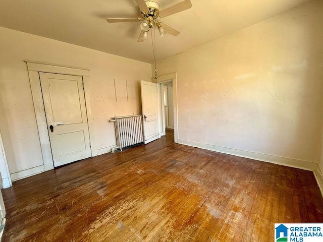 empty room featuring baseboards, ceiling fan, and hardwood / wood-style floors