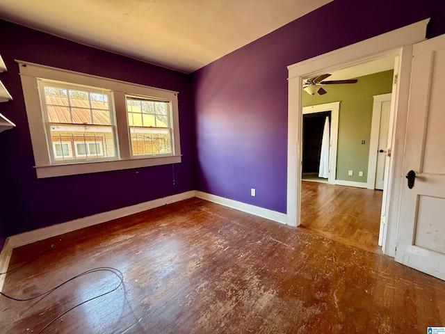 spare room with a ceiling fan, baseboards, and wood finished floors