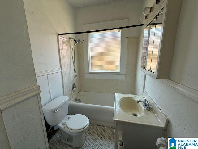 full bath with tile patterned flooring, toilet, shower / bath combination, wainscoting, and vanity