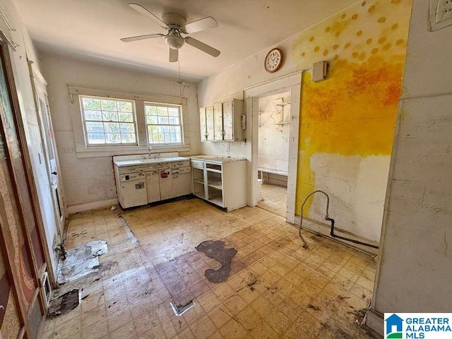 kitchen featuring a sink, light floors, a ceiling fan, and light countertops