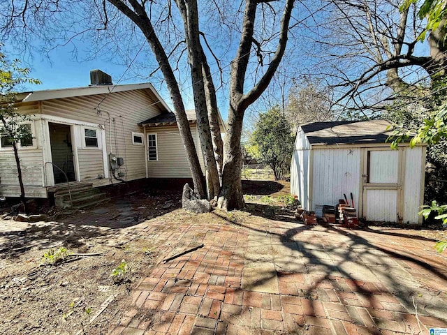 back of property with an outbuilding, a shed, a patio area, and entry steps