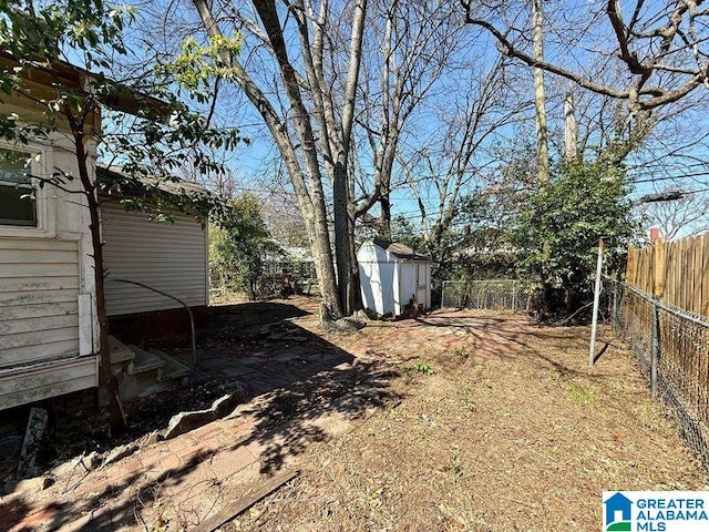 view of yard with a storage shed, an outbuilding, and fence