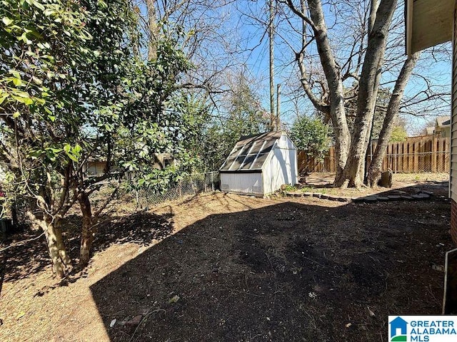 view of yard featuring an outbuilding, a storage unit, and a fenced backyard