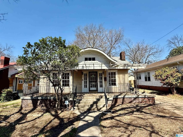 view of front of house with covered porch and a chimney