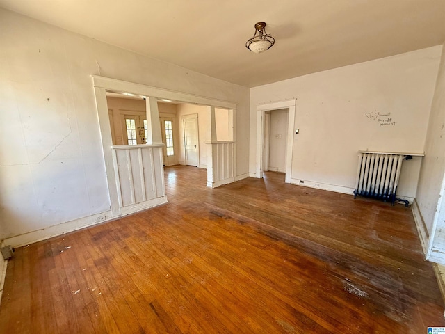 unfurnished room with hardwood / wood-style floors and radiator heating unit