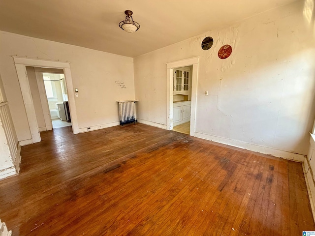 unfurnished room with baseboards and hardwood / wood-style flooring