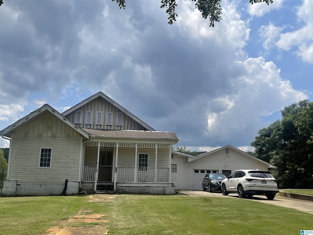 view of front of home featuring driveway, a porch, board and batten siding, an attached garage, and a front yard