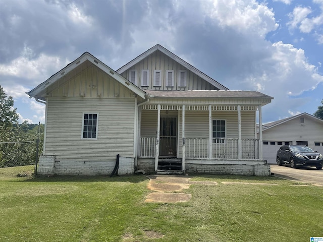 view of front of property featuring covered porch, board and batten siding, and a front yard