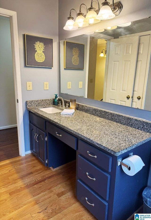 bathroom featuring vanity, wood finished floors, and baseboards