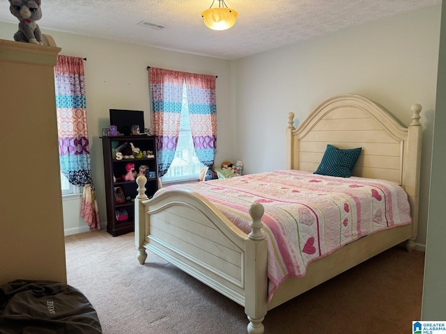 bedroom featuring baseboards, carpet flooring, a textured ceiling, and visible vents