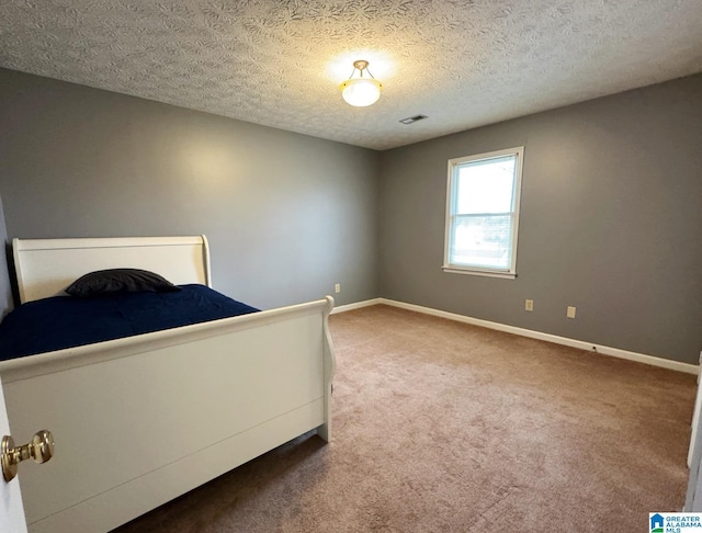 unfurnished bedroom featuring visible vents, baseboards, carpet, and a textured ceiling