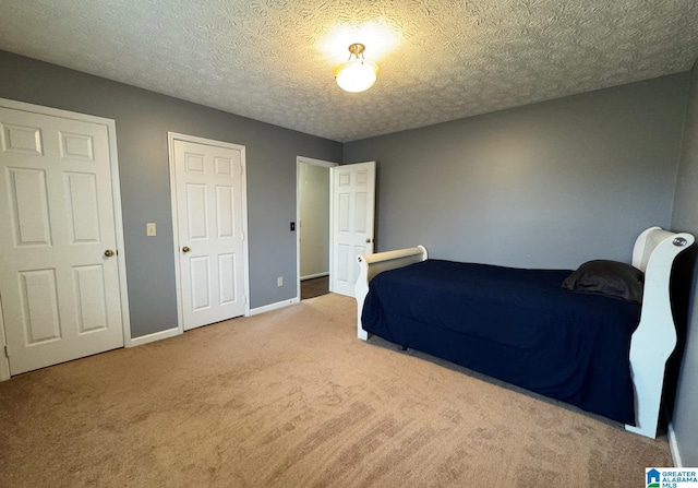 carpeted bedroom with baseboards and a textured ceiling