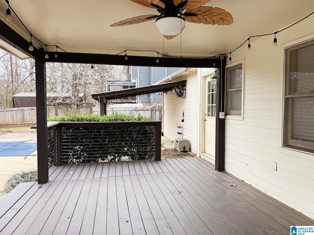 wooden terrace featuring ceiling fan and fence