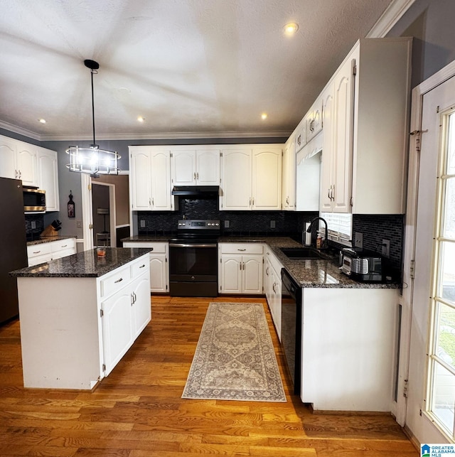 kitchen featuring a sink, black appliances, under cabinet range hood, white cabinetry, and a center island