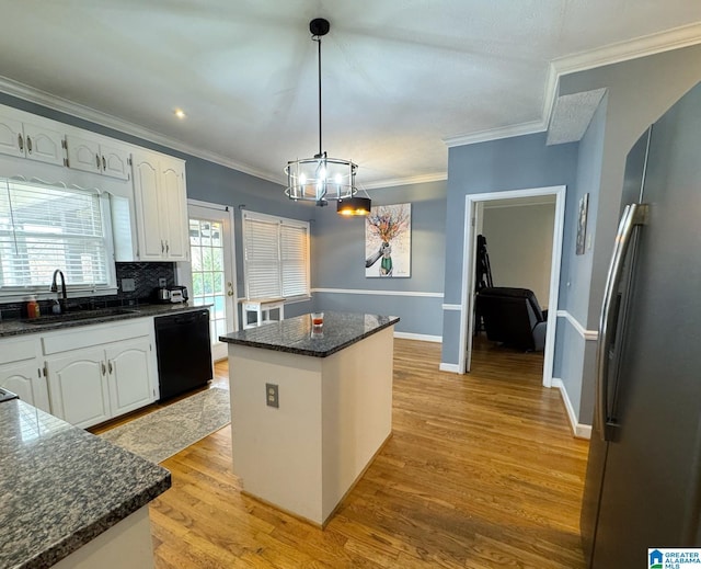 kitchen featuring light wood-type flooring, white cabinetry, freestanding refrigerator, and black dishwasher