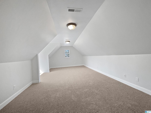 additional living space featuring lofted ceiling, carpet, visible vents, and baseboards